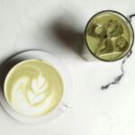 Elegant matcha latte with latte art and iced green tea on a marble table, perfect for tea enthusiasts.