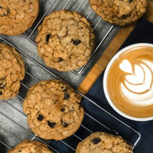 Indulge in homemade oatmeal cookies paired perfectly with a latte featuring beautiful latte art.