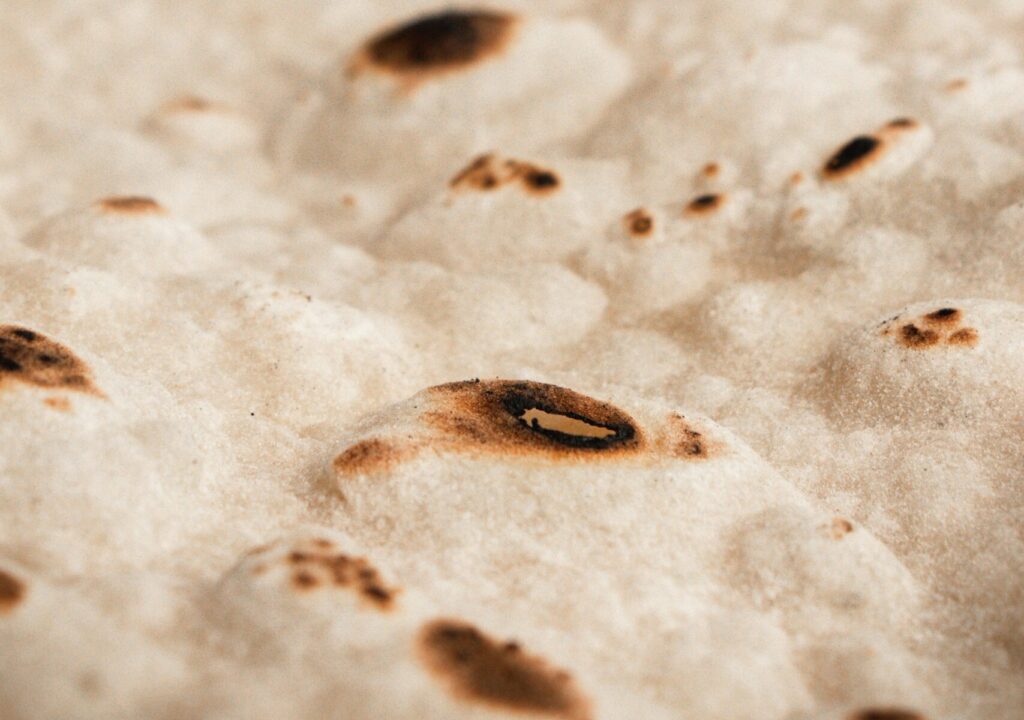Detailed close-up of freshly cooked Turkish flatbread with golden brown spots, showcasing texture.